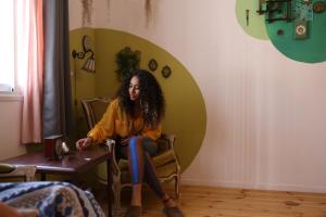 a woman sitting in a chair in a room at Rena's House in Tel Aviv