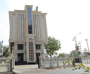 a large building with a fence in front of it at Sai Neem Tree Hotel in Shirdi