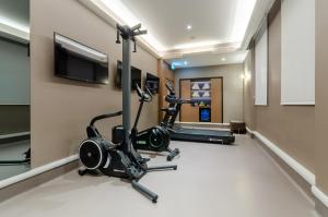 a room with a gym with a treadmill and a flat screen tv at Eurostars Lisboa Baixa in Lisbon