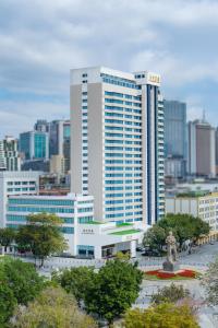 een groot gebouw met een standbeeld voor een stad bij Guangzhou Hotel - Haizhu square metro station & close to Beijing road in Guangzhou