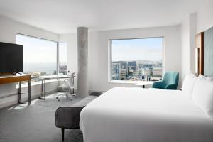 LUMA Hotel San Francisco - #1 Hottest New Hotel in the US 2023 في سان فرانسيسكو: غرفة في الفندق بها سرير ومكتب ونافذة