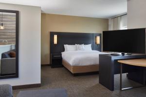 ein Hotelzimmer mit einem Bett und einem Flachbild-TV in der Unterkunft Residence Inn by Marriott Cleveland University Circle/Medical Center in Cleveland