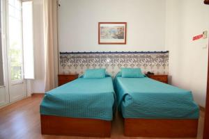 a bedroom with two beds with blue sheets at Residencial Joao XXI in Lisbon