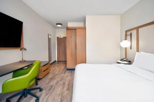 a room with a bed and a desk and a green chair at Fairfield by Marriott Inn & Suites Cincinnati North West Chester in West Chester