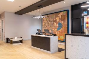 a lobby with two laptops on a large painting on the wall at Hyatt Place Gainesville Downtown in Gainesville