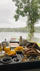 una mesa con comida y vistas al lago en Évika boutique hotel, en Eskilsby