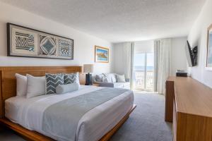 een slaapkamer met een groot bed en een woonkamer bij Mahalo Diamond Beach Resort in Wildwood Crest