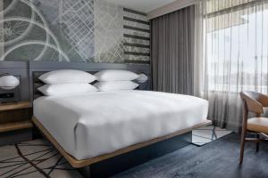 een slaapkamer met een groot bed met witte kussens bij Marriott Dallas Uptown in Dallas