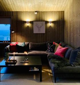 a living room with a couch and a table at Apartment with Electric car charger ski in out in Sjusjøen