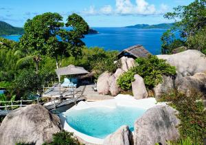 basen z dużymi skałami i wodą w obiekcie Château de feuilles & SPA - Praslin island w mieście Baie Sainte Anne