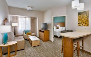 a hotel room with a bed and a living room at Staybridge Suites - Gainesville I-75, an IHG Hotel in Gainesville