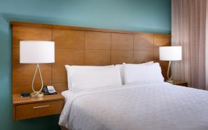 a bedroom with a large bed with two lamps at Staybridge Suites - Gainesville I-75, an IHG Hotel in Gainesville