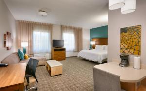 a hotel room with a bed and a living room at Staybridge Suites - Gainesville I-75, an IHG Hotel in Gainesville