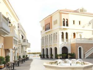 un edificio con una fontana di fronte a un edificio di The Ritz-Carlton Abu Dhabi, Grand Canal a Abu Dhabi