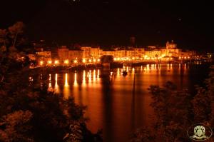 uma cidade à noite com luzes na água em Hotel Casa Arizzoli em Cannobio