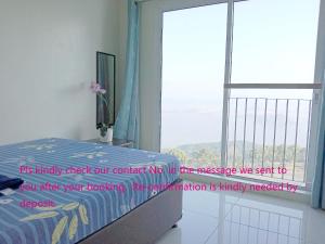 una camera con un letto e una grande finestra di SMDC Tagaytay Taal Lake Condo Cook Netflix No Balcony a Tagaytay