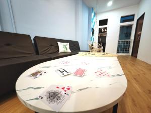 un tavolo bianco con carte da gioco in soggiorno di KTV, Dart & Snooker 4BR 16-20pax 4min walk to Jonker & Town a Malacca