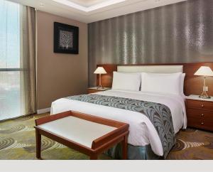 a hotel room with a bed and a table at Holiday Inn Kuwait Al Thuraya City, an IHG Hotel in Kuwait