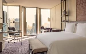 um quarto de hotel com uma cama e uma secretária com um computador em Four Seasons Hotel Seoul em Seul