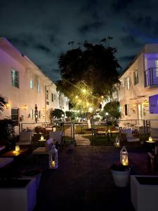 um grupo de edifícios com mesas e cadeiras à noite em Aqua Hotel em Fort Lauderdale