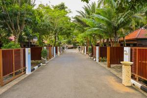 uma estrada com cerca e árvores à distância em Kranji Sanctuary Resort em Singapura