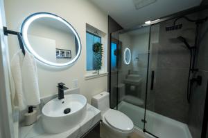 a bathroom with a sink and a toilet and a mirror at The Francis Boutique Inn in Ucluelet