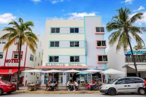 a white building with palm trees in front of it at Starlite Hotel in Miami Beach