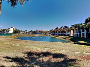 a body of water with houses and a palm tree at Edgewater Villa 2406 in Panama City Beach