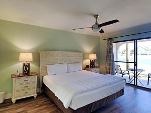 a bedroom with a large bed and a balcony at Edgewater Villa 2406 in Panama City Beach