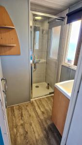 bagno con doccia, lavandino e specchio di Mobil home 6 personnes camping 4* Les Pins Maritimes a Hyères