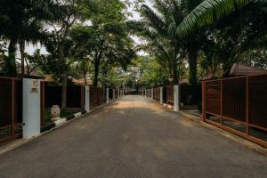 uma estrada vazia com uma cerca e palmeiras em Kranji Sanctuary Resort em Singapura