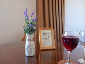 um copo de vinho e um vaso com flores sobre uma mesa em Apartman studio MINNA Osijek, free parking em Osijek