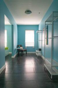 a bathroom with blue walls and a bench in a room at Beds n' Drinks in Miami Beach