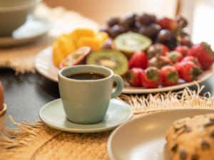 a cup of coffee next to a plate of fruit at Stayatsas Tiny House Julia in de bossen op de Veluwe! in Epe