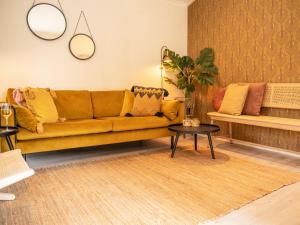 a living room with a yellow couch and a table at Stayatsas Tiny House Julia in de bossen op de Veluwe! in Epe