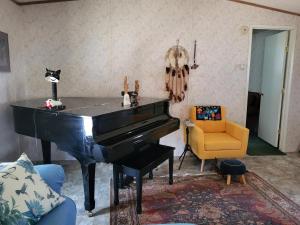 un piano negro en una sala de estar con una silla amarilla en A rest after a day in the Death Valley desert, en Scranton