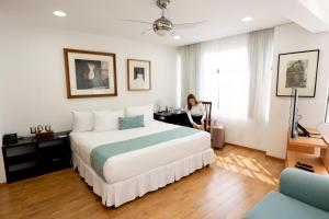 a woman standing in a hotel room with a bed at Suites Coben Apartamentos Amueblados in Mexico City