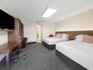 A bed or beds in a room at JetPark Hamilton Airport New Zealand