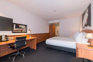 ein Hotelzimmer mit einem Bett, einem Schreibtisch und einem Computer in der Unterkunft Leonardo Hotel Utrecht City Center in Utrecht