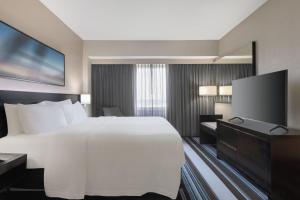 Habitación de hotel con cama grande y TV de pantalla plana. en Courtyard by Marriott New York JFK Airport, en Queens