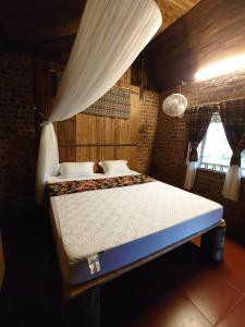 a bedroom with a large bed with a canopy at Homestay field - bungalow, Ha giang loop tour, motorbikes rental in Ha Giang