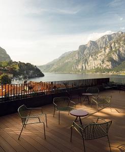 a balcony with chairs and tables and a view of the water at Hotel Promessi Sposi in Malgrate