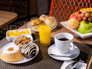 un tavolo con piatti per la colazione e una tazza di caffè di ibis Ponta Grossa a Ponta Grossa