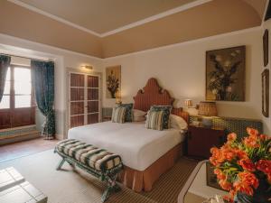 a bedroom with a bed and a bench in a room at Grand Hotel Son Net in Puigpunyent