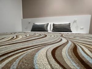 a bedroom with a large bed with a striped blanket at Anfitrite B&B Tropea in Tropea