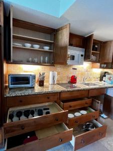 a kitchen with wooden cabinets and a counter top at Luana Waikiki Park Views in Honolulu