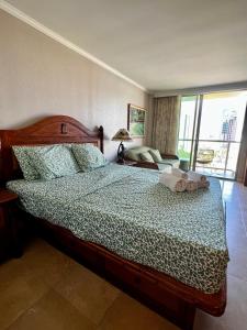 a bedroom with a bed with a green bedspread at Luana Waikiki Park Views in Honolulu