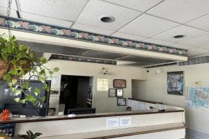 a waiting area of a waiting room with flowers on the wall at Kampus Inn by OYO Gainesville - University Area in Gainesville