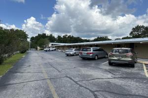 a parking lot with cars parked in front of a building at Kampus Inn by OYO Gainesville - University Area in Gainesville