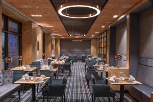 a restaurant with tables and chairs in a room at Maritim Hotel Ingolstadt in Ingolstadt